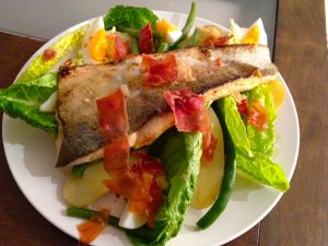Recept online: Sma�en� pstruh se sal�tem: Pstruh sma�en� v oko�en�n�m t�st��ku se sal�tem z brambor, raj�at, cibule a kopru